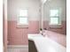 Bright bathroom featuring a white sink, pink tiling and large windows for ample natural light at 845 W 77Th St S Dr, Indianapolis, IN 46260