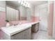 Clean bathroom with a white countertop, pink tile, and a large mirror, perfect for a quick refresh at 845 W 77Th St S Dr, Indianapolis, IN 46260