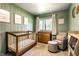 Cozy Bedroom with a crib, changing table, comfortable armchair, and soothing green walls at 845 W 77Th St S Dr, Indianapolis, IN 46260