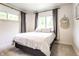 Bright bedroom with two windows, neutral decor, and a comfortable queen-sized bed at 845 W 77Th St S Dr, Indianapolis, IN 46260