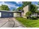 Well-maintained single-story home featuring a stone chimney and a charming entrance with flower beds at 845 W 77Th St S Dr, Indianapolis, IN 46260
