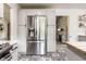 Bright kitchen featuring stainless steel refrigerator, custom cabinets, and decorative tile flooring at 845 W 77Th St S Dr, Indianapolis, IN 46260