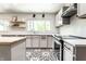 Modern kitchen with stainless steel appliances, floating shelves, and black and white patterned tile flooring at 845 W 77Th St S Dr, Indianapolis, IN 46260