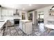 Modern kitchen with an island, stainless steel appliances, white cabinets, and eye-catching black and white tile flooring at 845 W 77Th St S Dr, Indianapolis, IN 46260