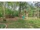 Backyard featuring a playground set, fire pit with seating, and wood pile at 846 W 56Th St, Indianapolis, IN 46228