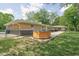 Backyard showcasing the home's exterior, hot tub, patio, and expansive lawn at 846 W 56Th St, Indianapolis, IN 46228