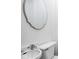 Clean bathroom with a pedestal sink, toilet, and decorative mirror at 846 W 56Th St, Indianapolis, IN 46228