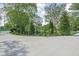 Driveway featuring a basketball hoop, landscaping, and mature trees at 846 W 56Th St, Indianapolis, IN 46228