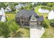 Aerial view of a two-story brick home with a three-car garage and well-landscaped backyard at 9037 Carnation Dr, Noblesville, IN 46060