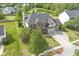 Aerial view of a two-story brick home with a three-car garage and backyard pond at 9037 Carnation Dr, Noblesville, IN 46060