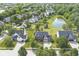 Aerial view of a two-story brick home with a three-car garage and nearby pond at 9037 Carnation Dr, Noblesville, IN 46060