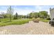 Expansive backyard featuring a pond, mature trees, and a lovely stone patio with a fire pit at 9037 Carnation Dr, Noblesville, IN 46060