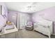 Purple-themed Bedroom with a crib, changing table, and rocking chair at 9037 Carnation Dr, Noblesville, IN 46060