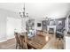 Open-concept dining room with a hardwood floor, modern chandelier, and view into a cozy living space at 9037 Carnation Dr, Noblesville, IN 46060