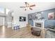 Living room with a fireplace, hardwood floors, and a blue accent wall at 9037 Carnation Dr, Noblesville, IN 46060