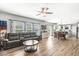 Open-concept living room with hardwood floors, a ceiling fan, and natural light from large windows at 9037 Carnation Dr, Noblesville, IN 46060