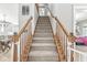 Carpeted staircase with wooden railing leading to the upper level of the home at 9037 Carnation Dr, Noblesville, IN 46060
