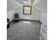 Spacious attic featuring a window, carpeting, modern lighting, and chair - ready for your personal touches at 908 E 32Nd St, Anderson, IN 46016