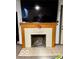 Classic fireplace with a decorative wooden mantle, creating a cozy focal point in the room at 908 E 32Nd St, Anderson, IN 46016