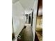 Hallway with neutral walls, leading to carpeted stairs and other rooms of the home at 908 E 32Nd St, Anderson, IN 46016