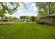 Large backyard with a well-maintained lawn, trees, and the home's exterior at 9303 Leroy Rd, Brownsburg, IN 46112