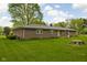 Manicured backyard with a brick house, lush green lawn and mature trees at 9303 Leroy Rd, Brownsburg, IN 46112