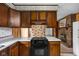 Cozy kitchen with wood cabinets, black stovetop and oven, and white countertops at 9303 Leroy Rd, Brownsburg, IN 46112