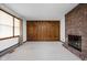 Carpeted living room featuring a brick fireplace and wood paneled accent wall at 9303 Leroy Rd, Brownsburg, IN 46112