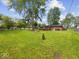 Expansive backyard featuring a well-maintained lawn, mature trees, and a charming brick home at 961 N Dellasburg Rd, Columbus, IN 47203
