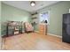 Cozy bedroom featuring wood-look floors, shelving, and a sunny window at 961 N Dellasburg Rd, Columbus, IN 47203