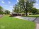 Classic brick home featuring a well-manicured lawn, driveway, and mature trees surrounding the property at 961 N Dellasburg Rd, Columbus, IN 47203