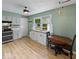 Bright kitchen featuring white cabinets, a window view, and a dining table at 961 N Dellasburg Rd, Columbus, IN 47203