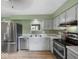 Well-equipped kitchen with stainless steel appliances, white cabinets, and hardwood floors at 961 N Dellasburg Rd, Columbus, IN 47203