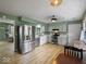 Kitchen with stainless steel appliances, hardwood floors, white cabinets, and a view to the living room at 961 N Dellasburg Rd, Columbus, IN 47203