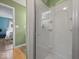 Bathroom featuring a glass-enclosed shower and a view into a bedroom with hardwood floors at 961 N Dellasburg Rd, Columbus, IN 47203