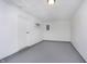Unfinished basement featuring painted floor, shelves, utility door and white painted walls at 10132 E 33Rd St, Indianapolis, IN 46235