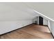Spacious finished attic featuring sloped ceilings, wood flooring, and a modern black door at 10455 Courageous Dr, Indianapolis, IN 46236