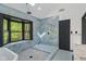 Elegant bathroom with blue marbled tile, a soaking tub, glass shower enclosure, and skylight at 10455 Courageous Dr, Indianapolis, IN 46236