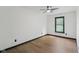 This bedroom features wood floors, white walls and ceiling, a ceiling fan, and a window with a view at 10455 Courageous Dr, Indianapolis, IN 46236
