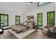 Bright bedroom with large windows offering a wooded view, neutral furnishings, and stair access at 10455 Courageous Dr, Indianapolis, IN 46236