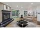 Bright living room with fireplace, sliding glass doors to deck, and seamless access to other parts of the home at 10455 Courageous Dr, Indianapolis, IN 46236