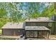 View of the rear exterior with a screened in porch and dark colored siding at 10455 Courageous Dr, Indianapolis, IN 46236