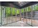 Beautiful screened-in porch with stone retaining wall and a view of the wooded lot beyond at 10455 Courageous Dr, Indianapolis, IN 46236