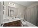 Well-lit bathroom features a wooden vanity with sink, toilet and bathtub with shower at 10599 Geist View Dr, Fishers, IN 46055