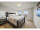 Comfortable bedroom features soft carpet, a large bed, and bright natural light from two windows at 10599 Geist View Dr, Fishers, IN 46055