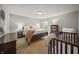 Bright bedroom with soft carpet features a crib, bookcase, and windows providing natural light at 10599 Geist View Dr, Fishers, IN 46055