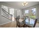 Inviting dining room with glass table, chandelier, and views of staircase and front entry at 10599 Geist View Dr, Fishers, IN 46055
