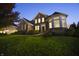 Beautifully lit two-story home with large windows and well-maintained landscaping at dusk at 10599 Geist View Dr, Fishers, IN 46055