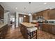 Open kitchen with dark wood cabinets, stainless steel appliances, and granite island with seating at 10599 Geist View Dr, Fishers, IN 46055