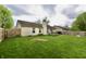 Wide view of a backyard, showcasing the expansive lawn, privacy fence, and wood deck at 10688 Ashview Dr, Fishers, IN 46038